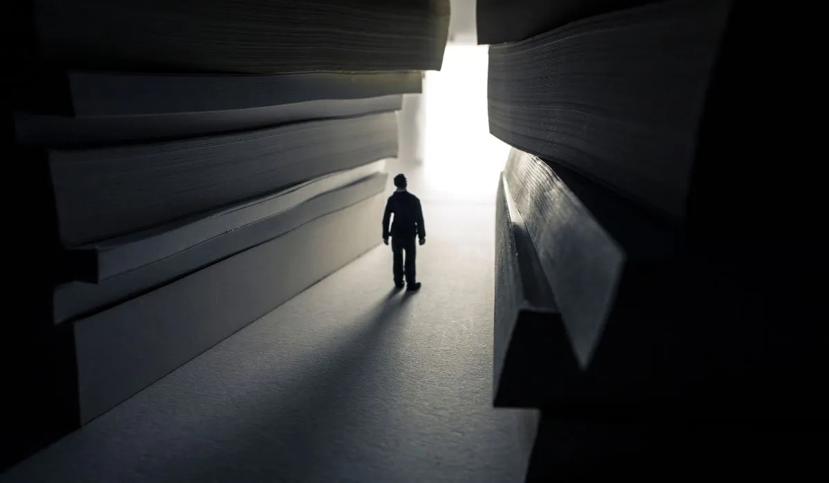 A man stepping from darkness into light, symbolizing the enlightenment brought by books in his life.